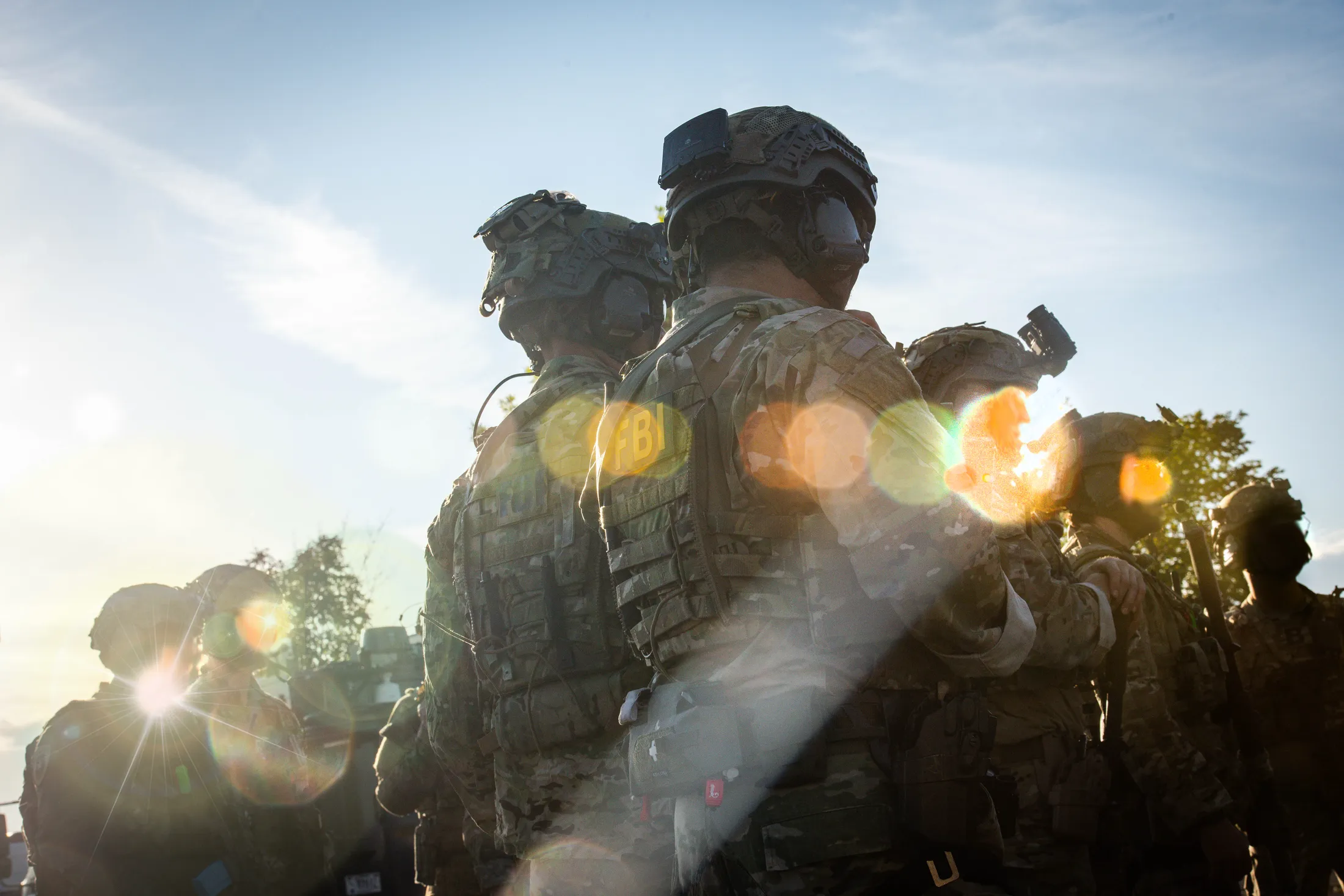 FBI agents backlit by the sun before a training raid during Exercise Hellgate at Camp Orchard, Idaho, photo by Rusty Rehl