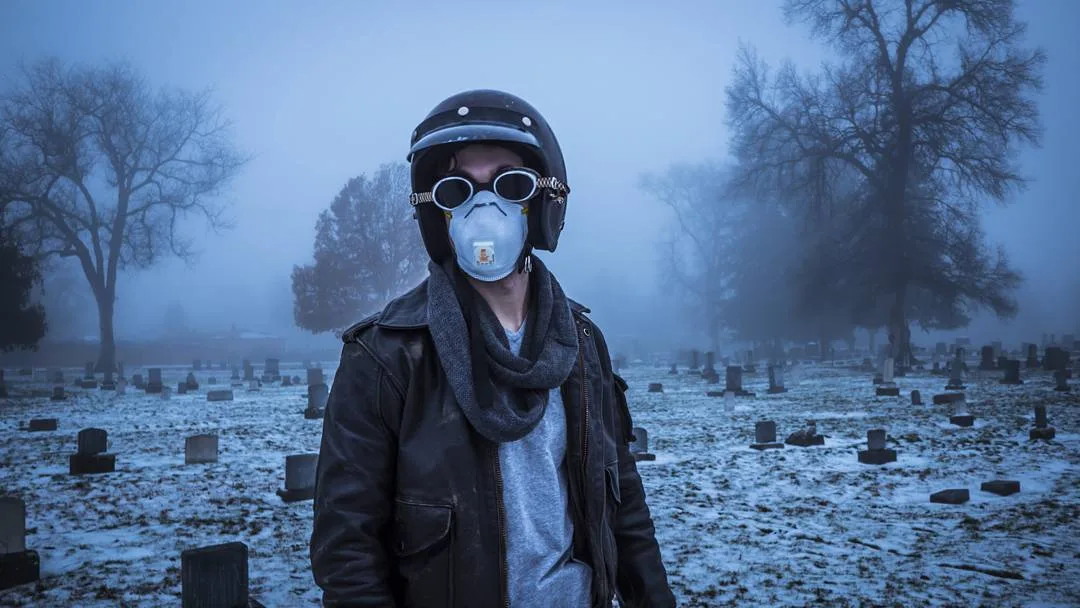 Still from a Rusty Rehl short film: a figure in a helmet, goggles and dust mask stands in a foggy, snow-dusted cemetery