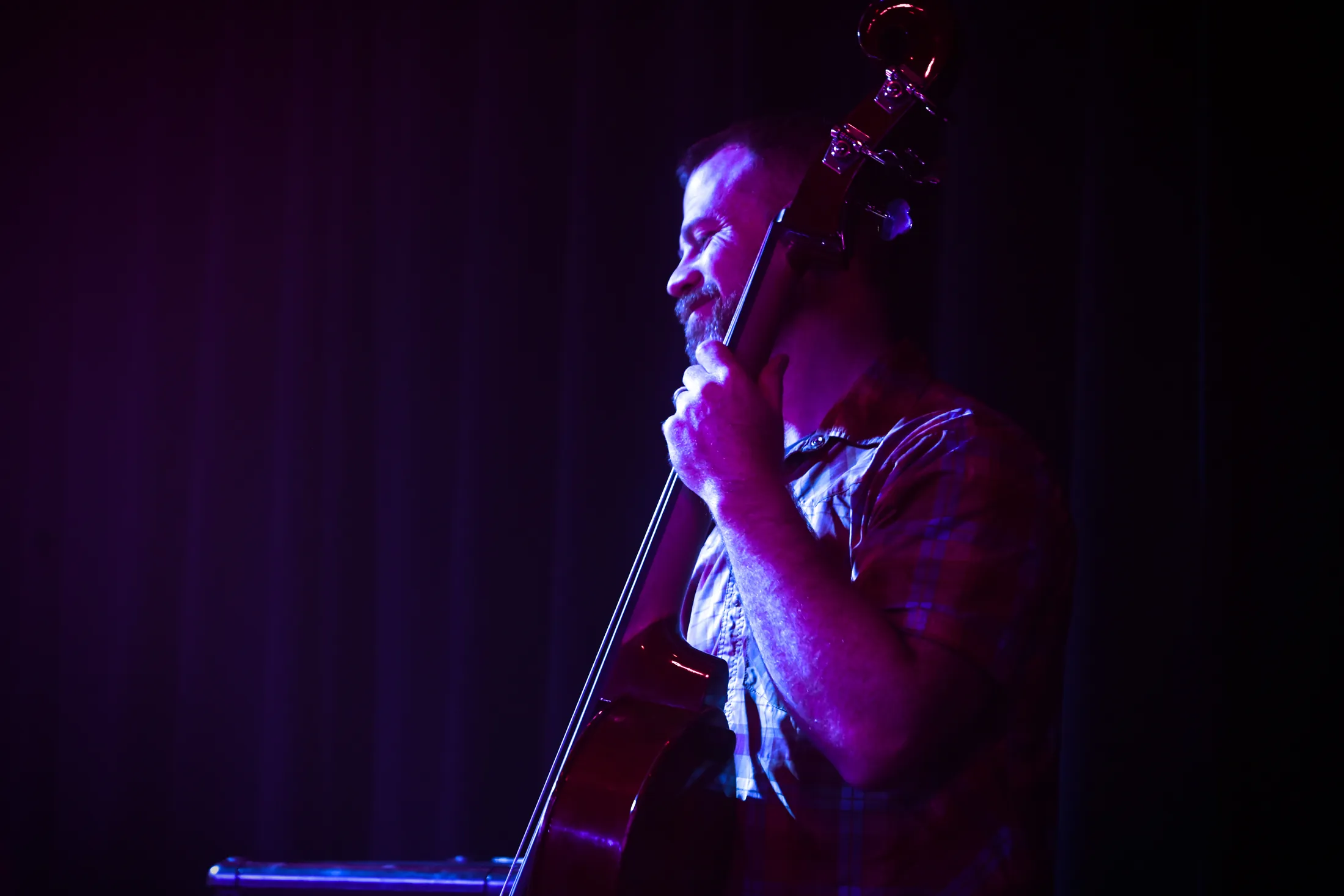 Upright bass player in shadow on a dark stage, Boise, Idaho concert photo by Rusty Rehl