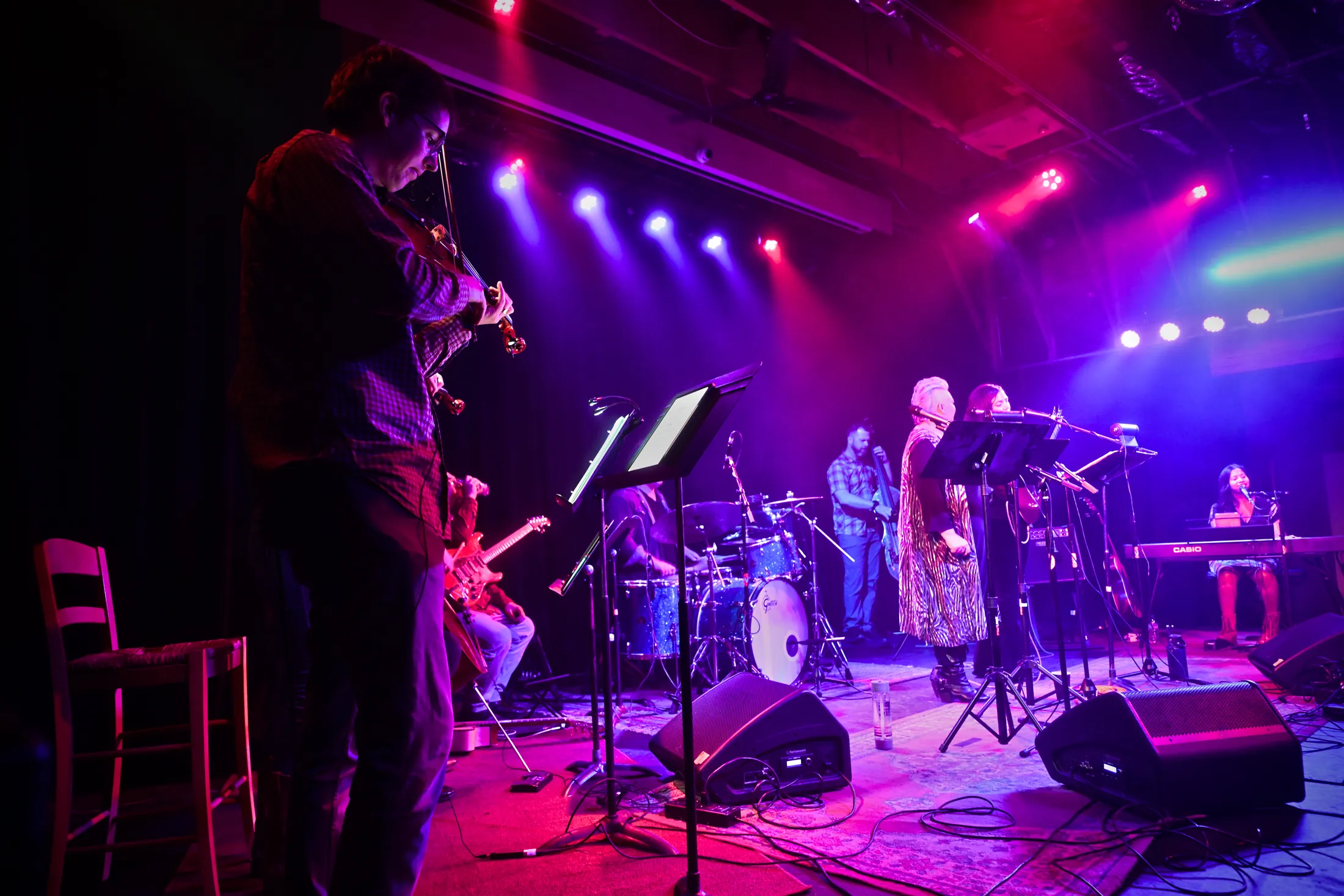 Violinist watching from the side of the stage while the band plays, Boise, Idaho concert photo by Rusty Rehl