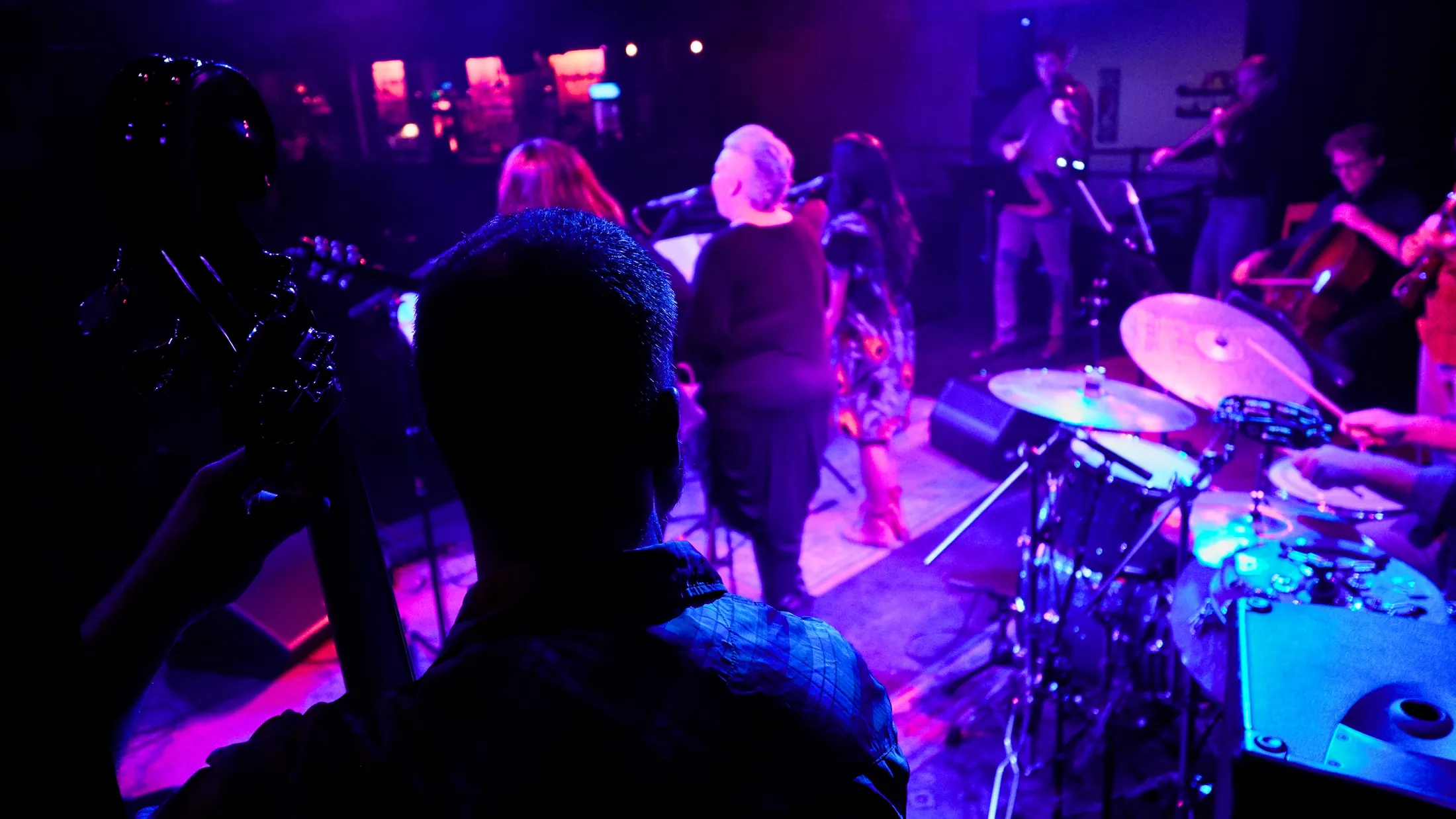 Over the drummer's shoulder toward the singers, Boise, Idaho concert photo by Rusty Rehl