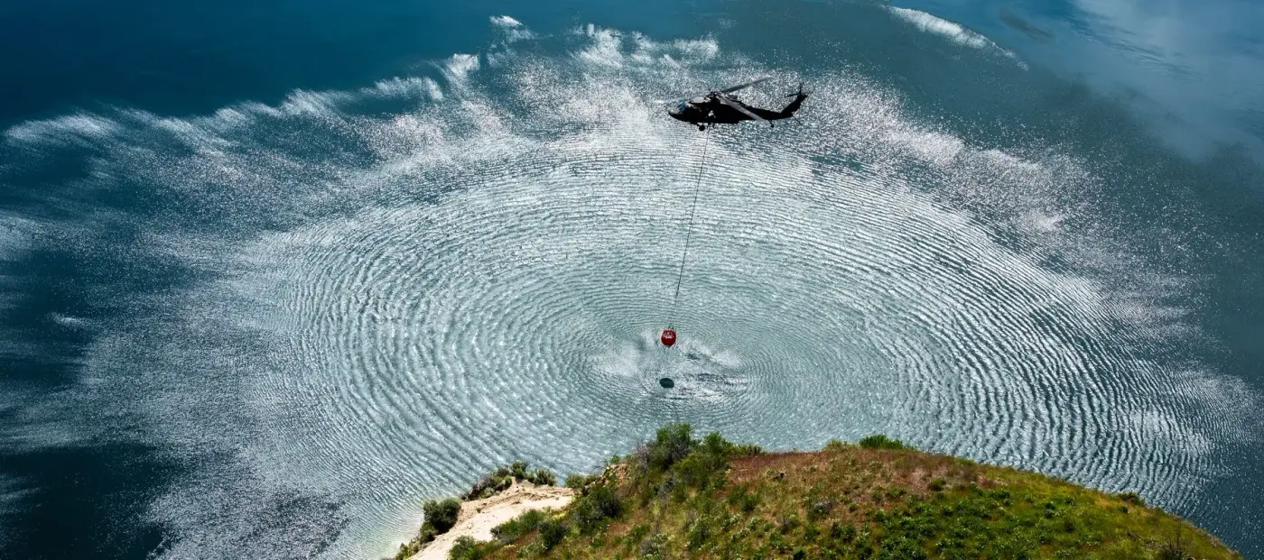 Aerial view of an Idaho Army National Guard UH-60 Black Hawk filling a water bucket, photo by Rusty Rehl
